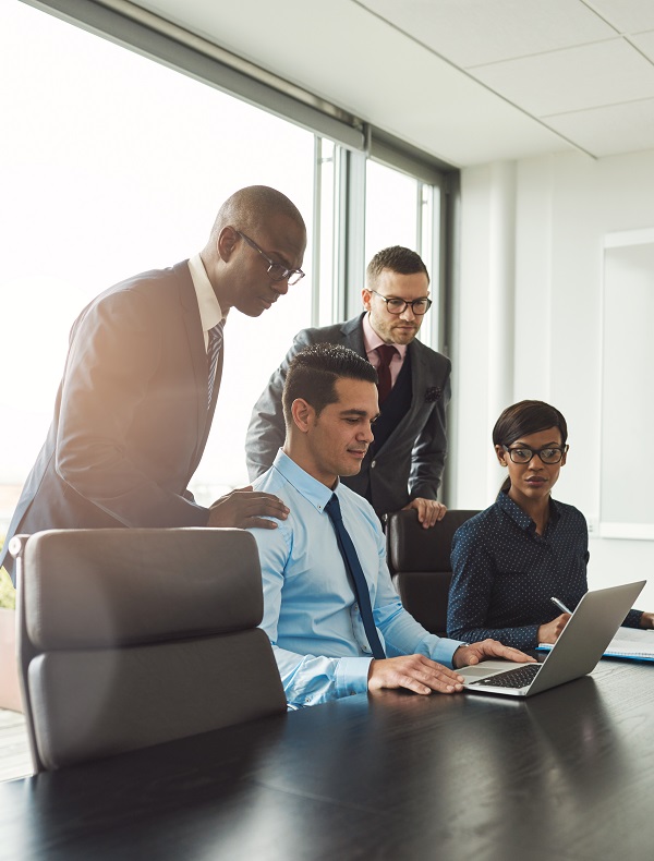 Group Of Co Workers Looking At Laptop On Table